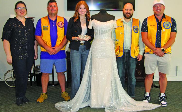 Sentinel Photo/Jessica Shepard Bay City Lions Club members pose with this year’s Rice Festival Queen dress, sponsored by New Beginnings Bridal & Prom in El Campo on Sept. 5. Pictured from left are: Lions Club Rice Festival Queen Pageant Director Rachel Ricks, Lions Club President Mike Griffith, New Beginnings Bridal & Prom representative Kasey Burns, Lions Club Rice Festival Queen Pageant Chairman Ryan Ricks, and Lions Club Rice Festival Chairman Trent Tinnin.