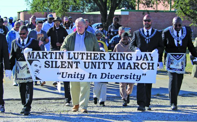 Sentinel Photo/Jessica Shepard Almost 80 citizens participated in the annual "Martin Luther King, Jr. Silent Unity March"  on Monday, Jan. 19.  Attendees walked roughly five blocks to the Hilliard High Alumni Building while holding a variety of posters and photographs depicting King. Elected officials present included Matagorda County Judge Bobby Seiferman, Bay City Mayor Robert Nelson, and Councilman Ben Flores.