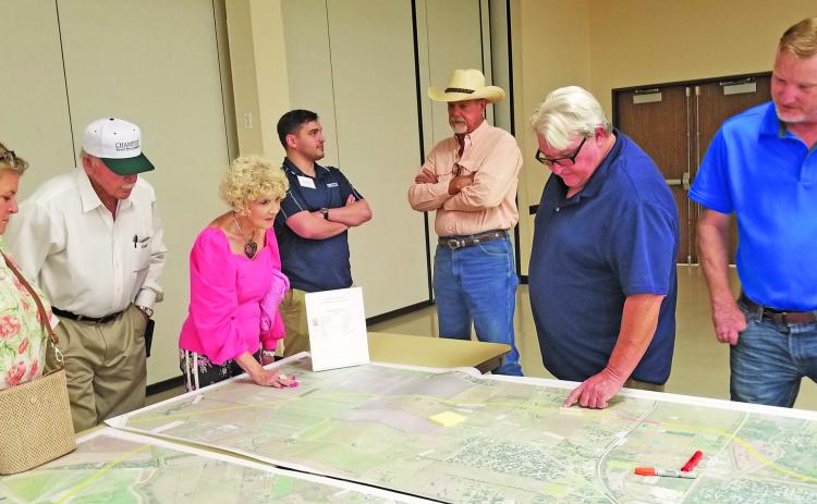 Sentinel Photo/Mike Reddell People gather around a TxDOT map of a possible route relief at a recent information session at the Bay City Civic Center.