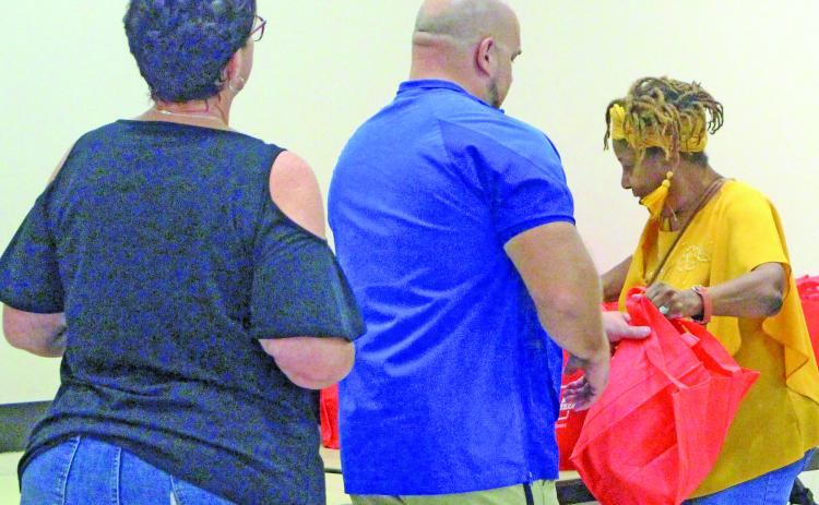Sentinel Photo/Jessica Shepard Bay City Chamber of Commerce & Agriculture Education Committee volunteer and retired Bay City ISD staff member Donnye Stone, right, hands out goody bags to BCISD’s newest teachers at the annual “New Teacher Breakfast” on Aug. 6.